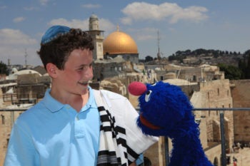 Michael Rosenberg of New York City chats with Grover, who attended his bar
mitzvah in Jerusalem as part of the "Shalom Sesame" filming, on Aug. 28, 2009. (Koby Gideon / Flash 90)