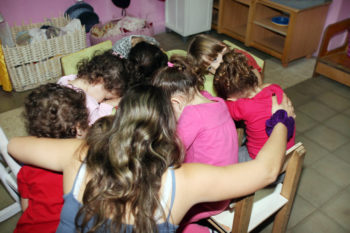Young children practicing taking cover in the event of an air raid siren in the Tel Aviv area, Nov. 18, 2012. 

 (Gideon Markowicz/FLASH90)