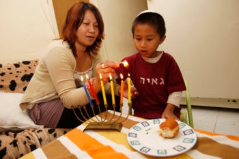 Filipinos light Chanukah candles in their home in South Tel Aviv on Nov. 24, 2010 in advance of the Jewish holiday.  (Miriam Alster/FLASH90)