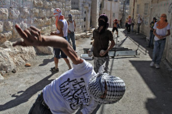 Arab youths hurl stones at Israeli border policemen in the eastern Jerusalem neighborhood of Ras al-Amud on Oct. 6, 2009.  (Nati Shohat / Flash 90 / JTA)
