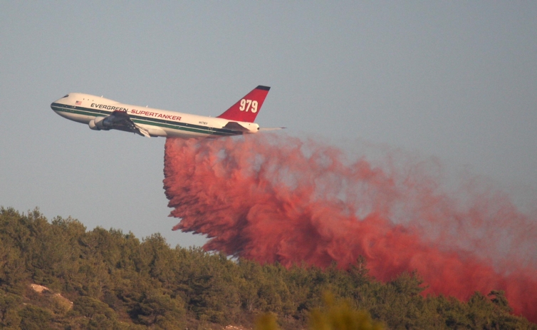 A Boeing 747 from the United States brought in to help fight Israel's largest fire on its fourth day sprays fire-extinguishing material, Dec. 5, 2010. (Meir Partush/Flash 90)