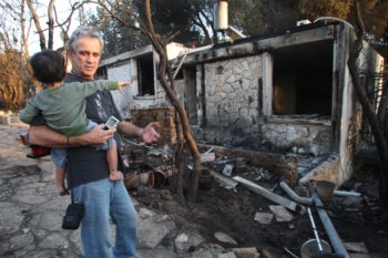 Father and son look at their house in Ein Hod, near Haifa, that was burned down in the fire that ravaged the Carmel Forest, Dec. 5, 2010. (Meir Partush/Flash 90)