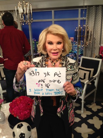 Joan Rivers holding a sign in support of a gay Israeli couple that reads, "I want them to have a baby too!" (Courtesy A Wider Bridge)