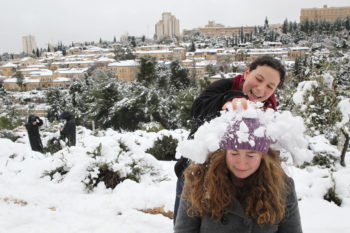 Young Israelis playing in the snow, with the snowy Jerusalem neighborhood Mishkenot Sha'ananim in the background, Jan. 10, 2013. (/JTA)  (Nati Shohat/Flash90)