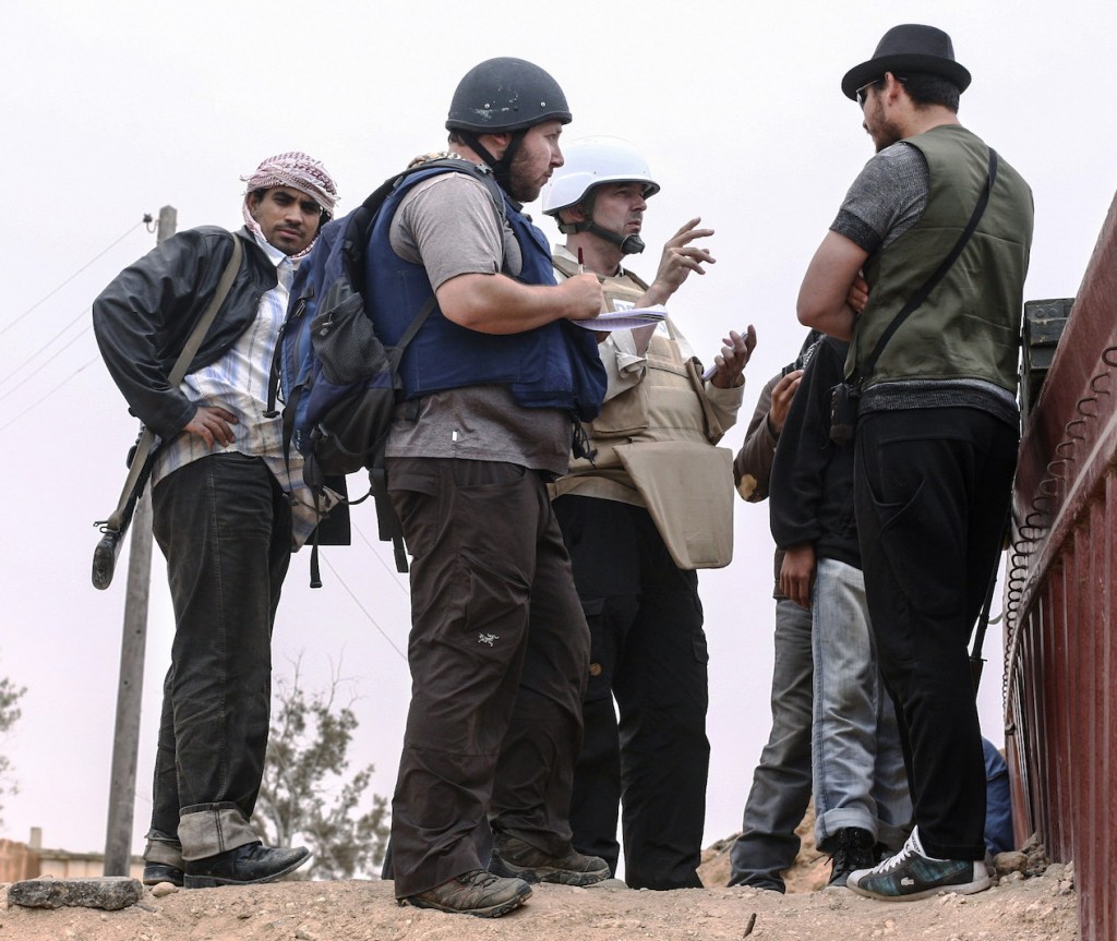 In this handout image made available by the photographer, American journalist Steven Sotloff (center with black helmet) talks to Libyan rebels on the Al Dafniya front line, 25 km west of Misrata, June 2, 2011.  Sotloff was kidnapped in August 2013 near Aleppo, Syria.  (Etienne de Malglaive via Getty Images)