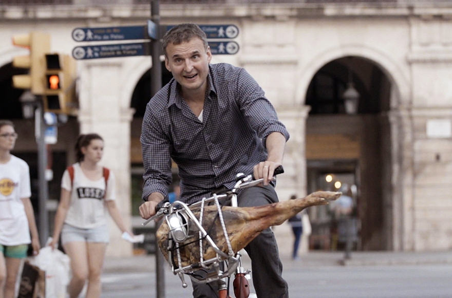 Rosenthal, biking with a ham in Barcelona, in a scene from "I'll Have What Phil's Having." (Courtesy WGBH)
