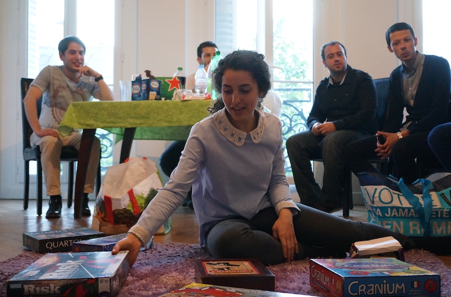 Noemie Grausz showcasing board games for her guests at Moishe House Beaubourg in Paris, May 18, 2016. (Cnaan Liphshiz)