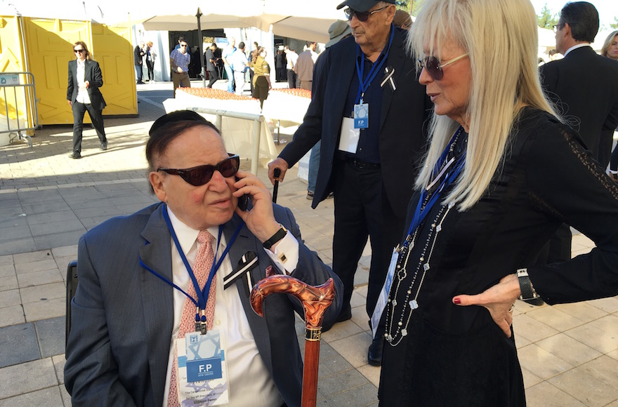 Sheldon Adelson speaking with Army Radio by phone at the funeral of Shimon Peres at Mount Herzl national cemetery in Jerusalem, Sept. 30, 2016. (Andrew Tobin)