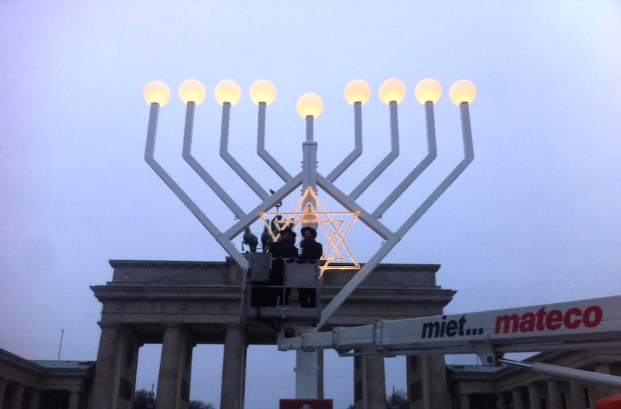 Rabbi Yehudah Teichtal, left, and a colleague testing out a Hanukkah menorah at Brandenburg Gate in Berlin, Dec. 22, 2016. (Courtesy of Teichtal) 