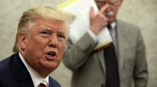 President Donald Trump speaks to members of the media as National Security Adviser John Bolton listens during a meeting with President of Romania Klaus Iohannis in the Oval Office of the White House, Aug. 20, 2019. (Alex Wong/Getty Images)