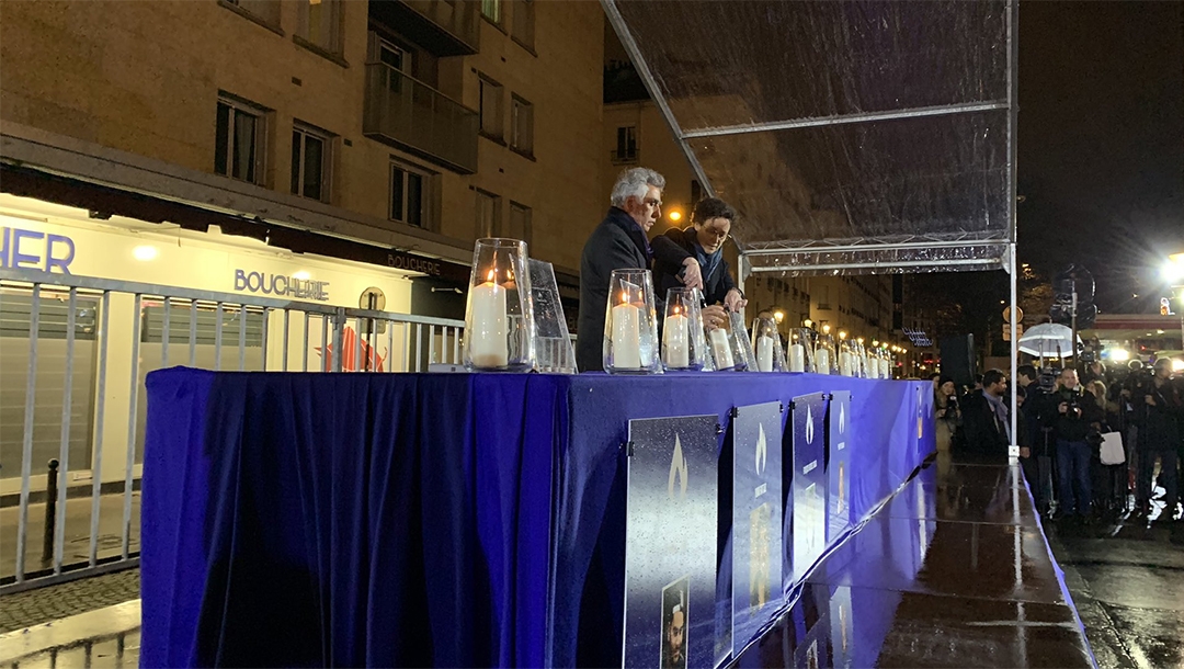 Senior French government official Emmanuelle Wargon and CRIF board member Serge Dahan lighting a memorial candle outside the Hyper Cacher store in Paris, France on Jan. 9, 2020. (Courtesy of CRIF)