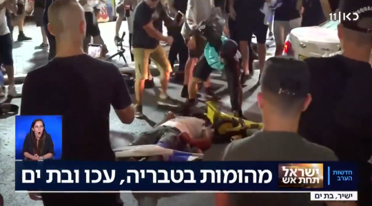 A man beats someone lying prone on the ground in the Israeli city of Bat Yam, amid interethnic violence across Israel. (Screenshot)