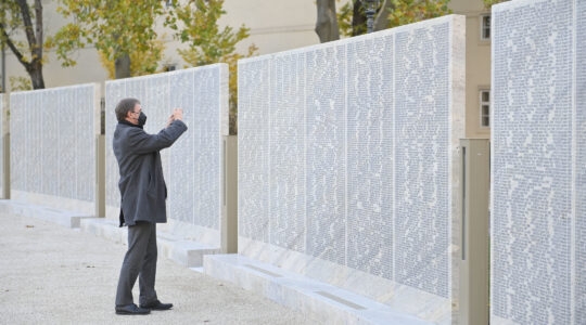 A man takes a picture at the Shoah Name Wall Memorial in Vienna, Austria on November 9, 2021. (Hherbert Neubauer/APA/AFP via Getty Images)