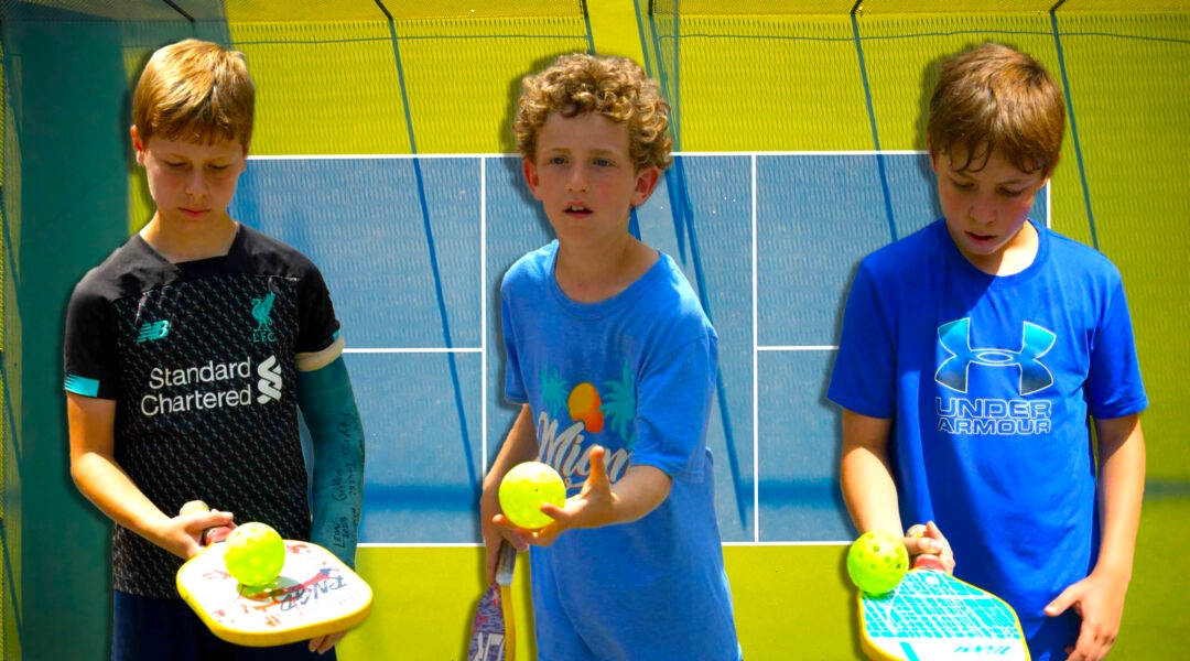 Kids holding pickleball paddles