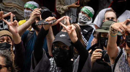 Protesters flash an inverted triangle, a Hamas symbol, at Baruch College in New York City, June 6, 2024. (Luke Tress).