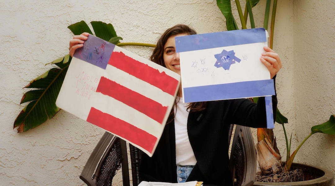 A woman holds up handmade images of the U.S. and Israeli flag