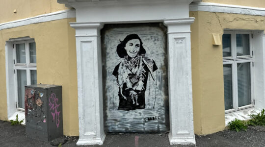 A mural of Anne Frank wearing a keffiyeh on a street corner