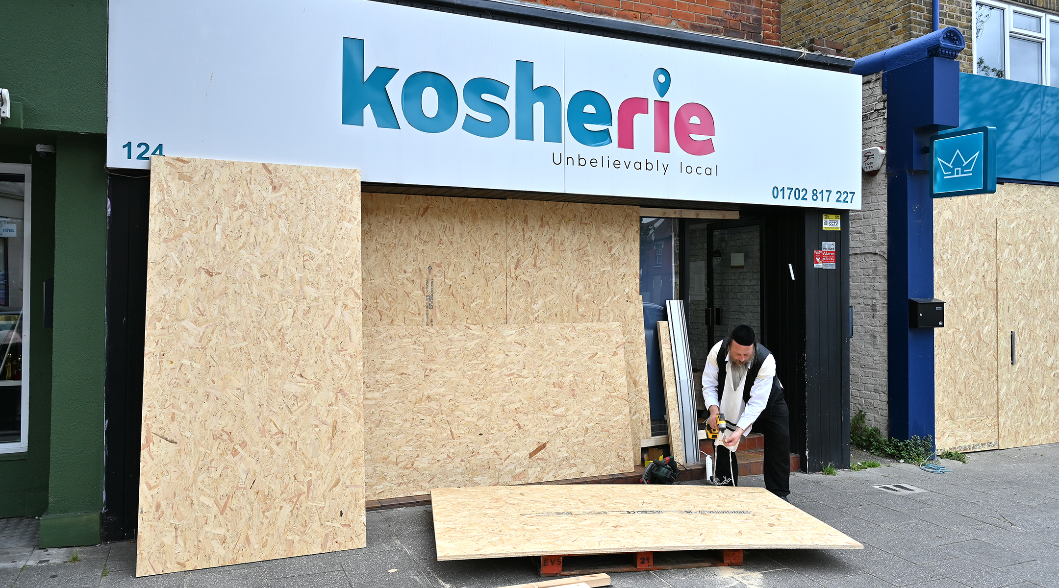 A kosher food shop is boarded up in preparation for more unrest.