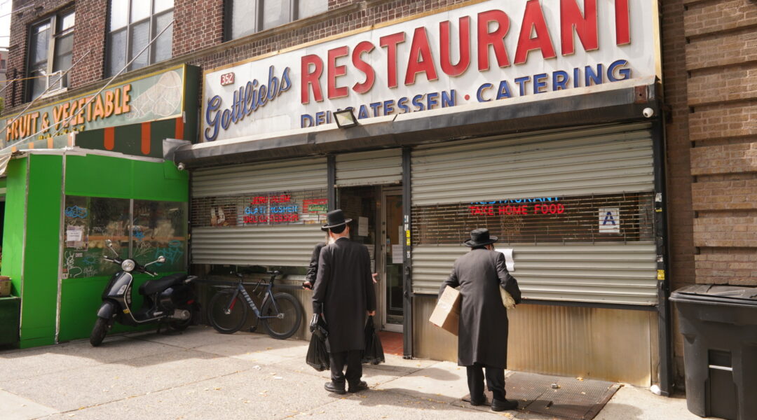 Passersby read notices for the funeral of the owner of Gottlieb's Restaurant in Williamsburg, Sept. 19, 2024. (Luke Tress)