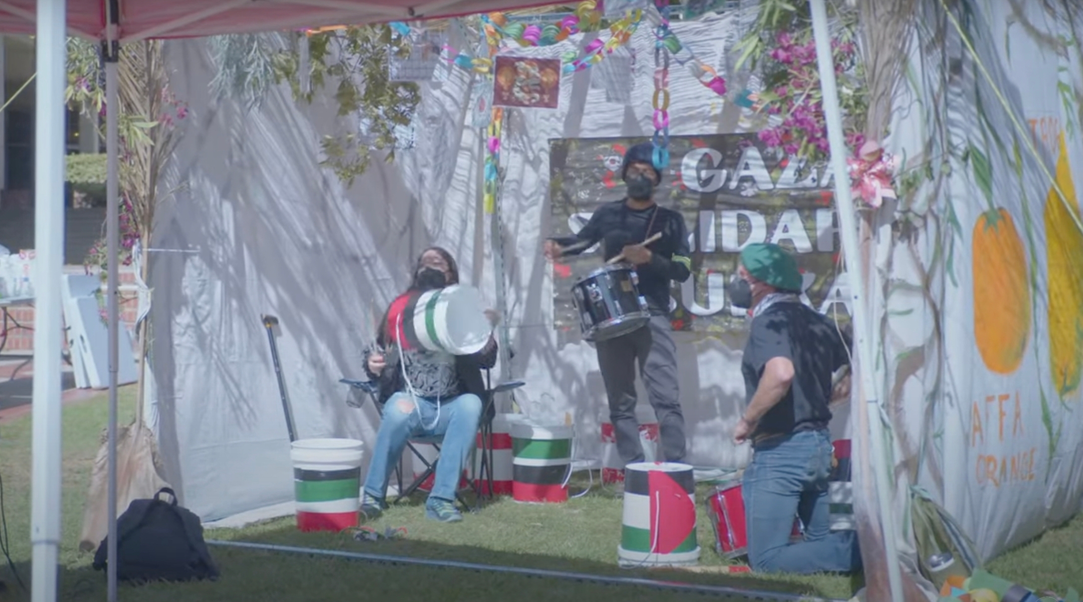 Drummers play inside a Gaza solidarity sukkah on the campus of UCLA in Los Angeles, California, Oct. 22, 2024. Campus police would later break up the sukkah and arrest one person. (The Daily Bruin / Screenshot via YouTube)