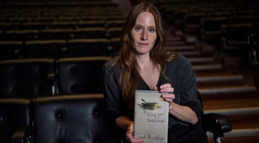 An author holds her book for the camera