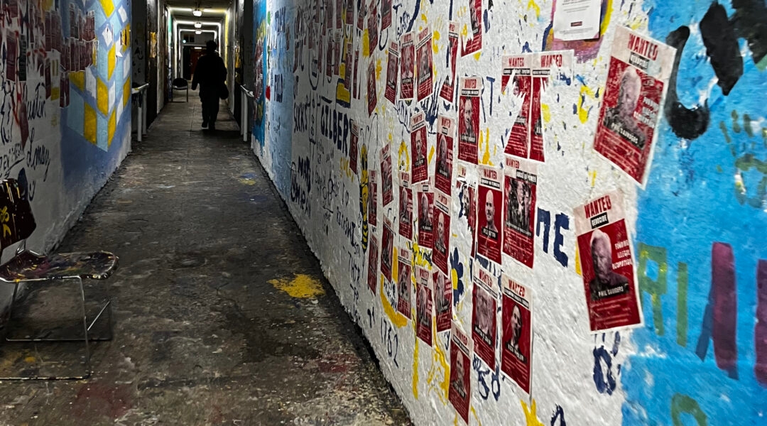 A university hallway filled with red "Wanted" posters