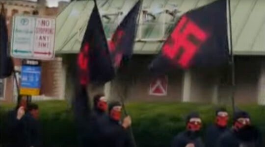 Young men marching outside with swastika flags