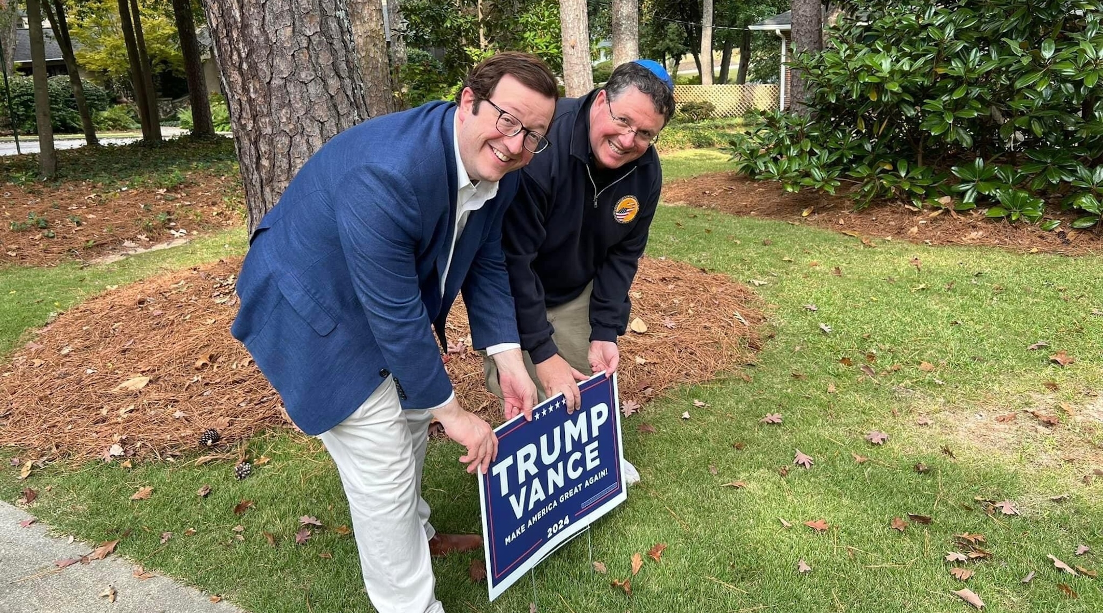 Two Jewish men pose with a "Trump/Vance" yard sign