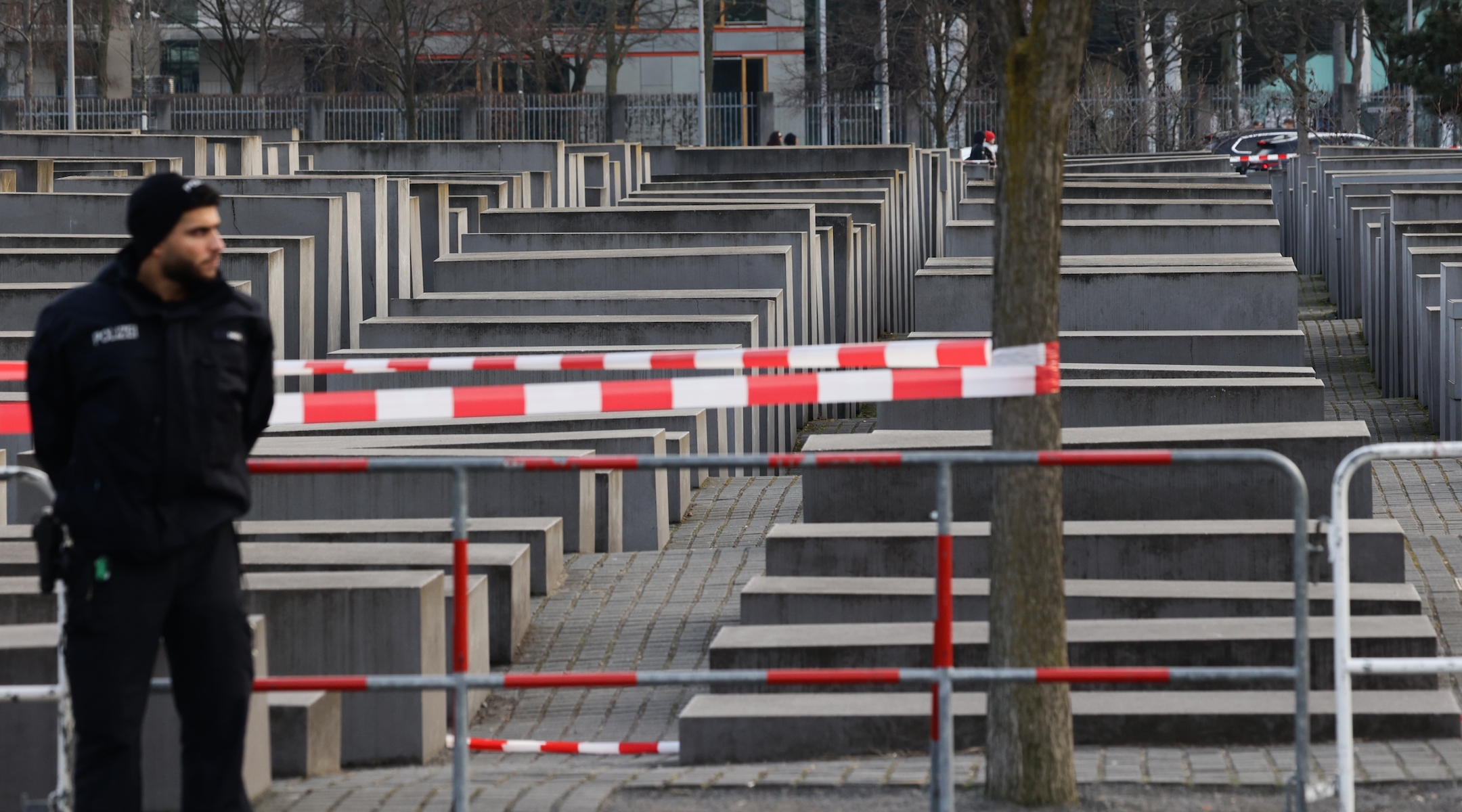 Caution tape and a police officer around a Holocaust memorial